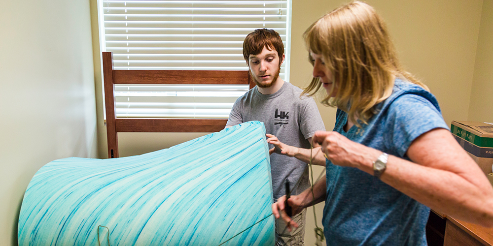 Arts and technology freshman Brett Austin receives help from his mother as he unpacks his room.