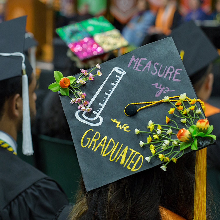 Cap that says measure up we graduated