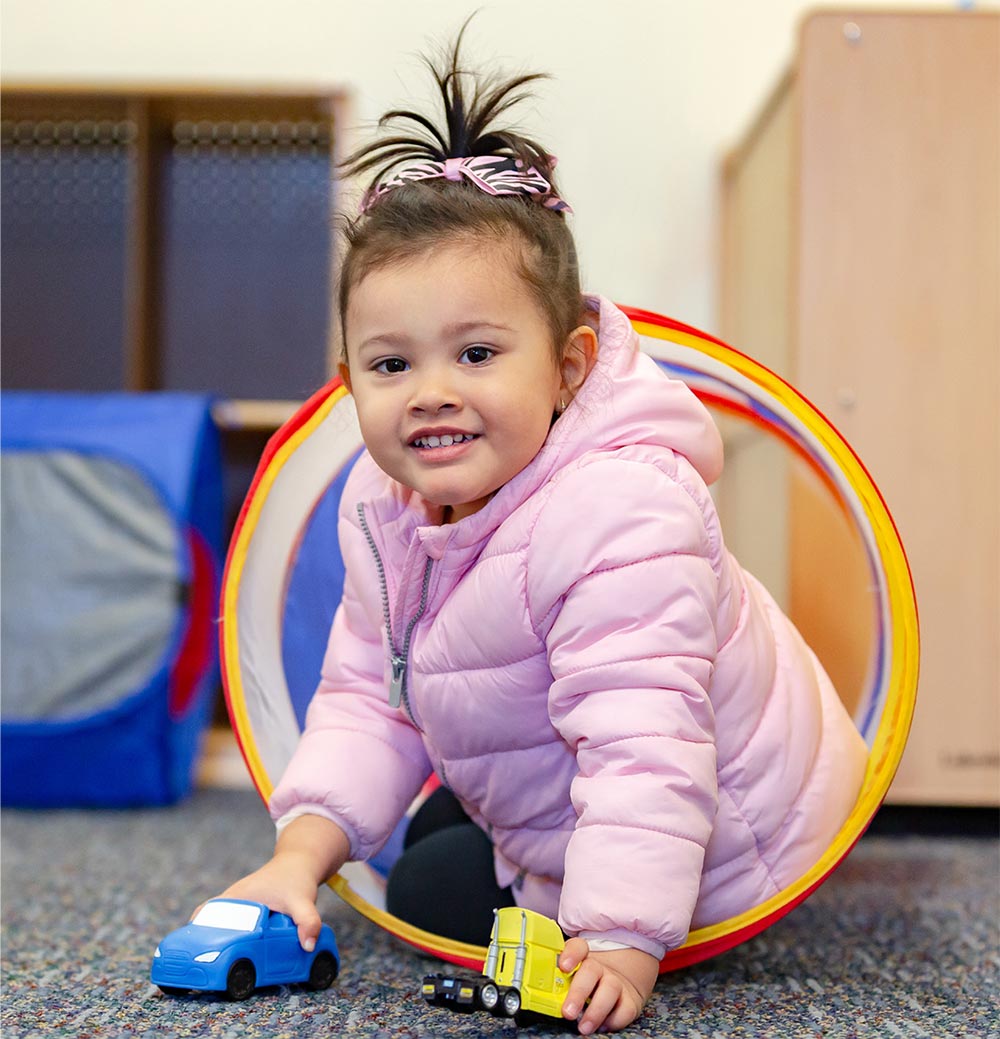 A child plays with toy cars