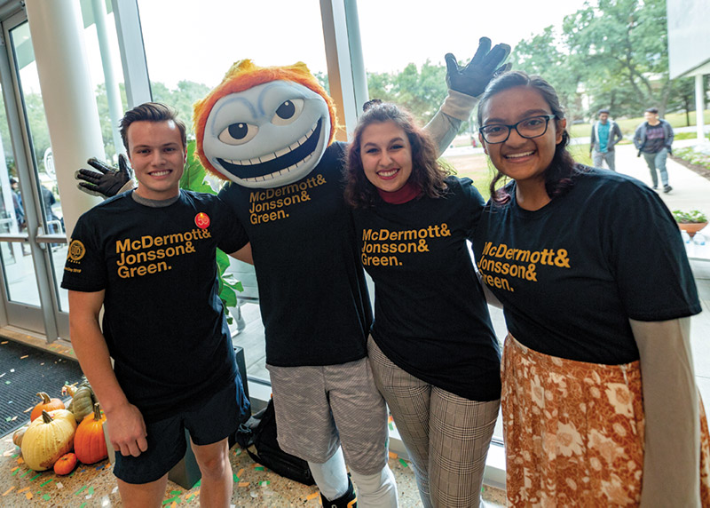 Three students at Founders Day pose with Temoc.